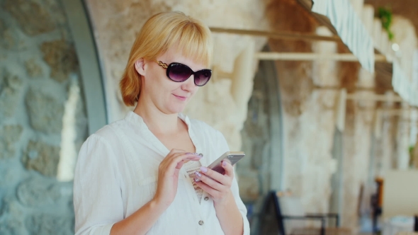 Attractive Woman Writing Sms On a Background Of a Typical Italian Restaurant alt