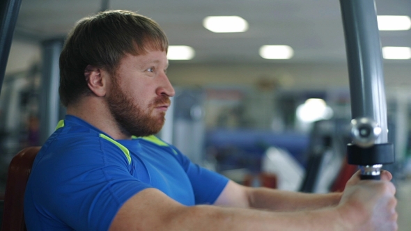 Athletic Man Doing Exercises In a Gym