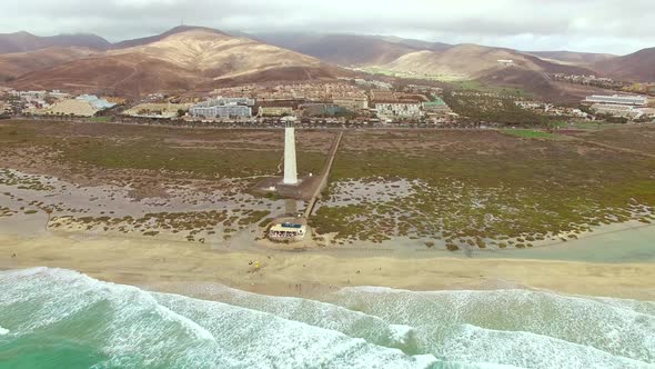Aerial view of Morro Jable Lighthouse with cloudy weather. alt