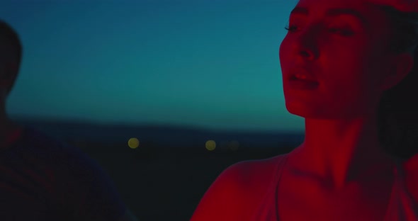 Multiethnic Group of Athlete Resting After Running in Night Time on a Panoramic Road