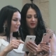 Two Girls Are Watching Photos On a Mobile Phone - VideoHive Item for Sale