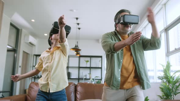Dad and son wear VR or virtual reality glasses,headsets standing and playing a video game