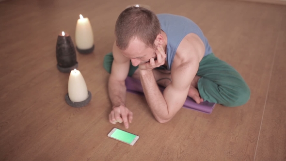 Man Using Phone While Sitting In Lotus Pose alt