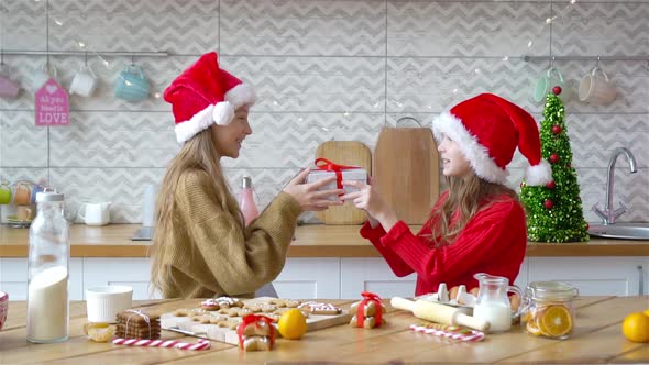 Little Girls with Gift on Christmas in Decorated Living Room