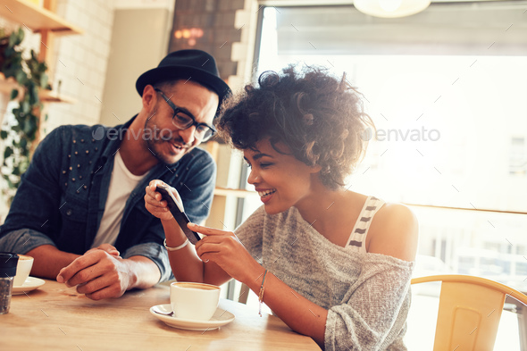 Friends in cafe using mobile phone - Stock Photo - Images