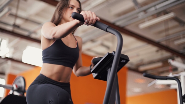Female On Gym Bike Doing Cardio Exercise alt