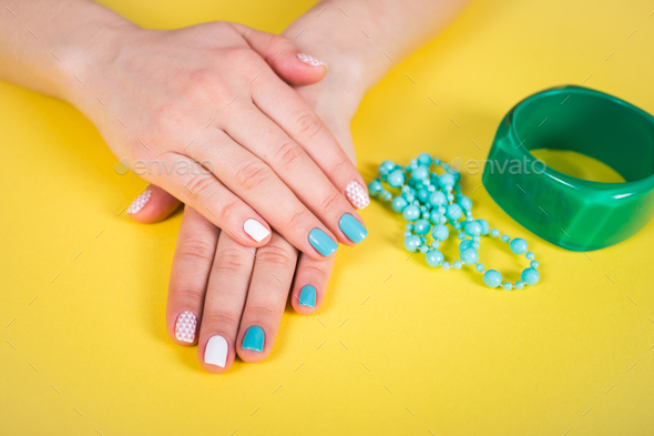 beautiful manicure. gel polish coating in white and turquoise, stamping. Stock Photo by ollinka