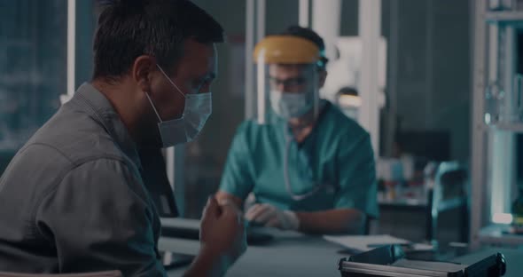 Coughing Man Speaking with Doctor in Hospital alt