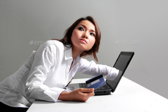 Businesswoman working with laptop holding credit card buying onl