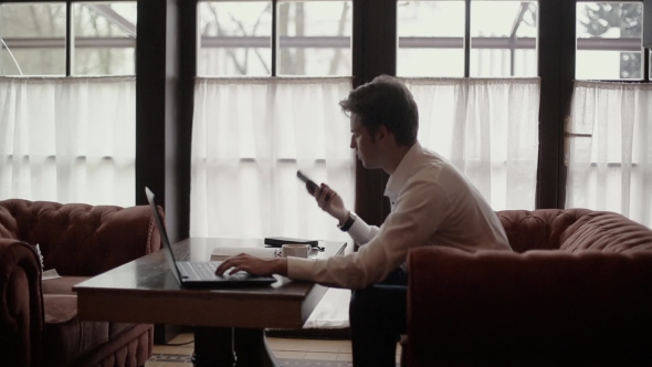 The Man Works For Laptop And Talking On The Phone alt