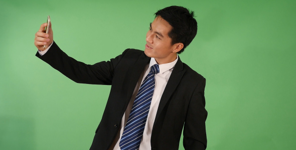Asian Businessman Taking a Selfie alt