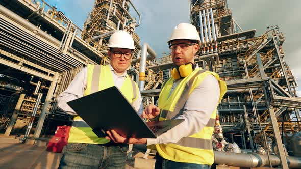 Engineering Colleagues are Having a Talk on the Oil Refinery Premises alt