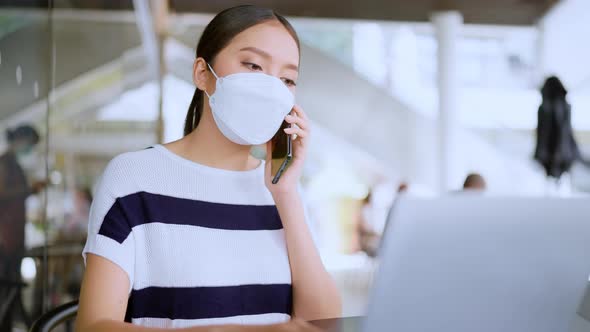 asian female wear casual cloth and face mask protecting hand use smartphone and laptop