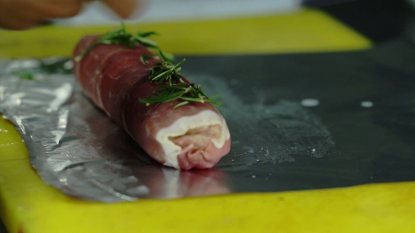 Chef Pours Oil Pieces Of Ham Rolled In Sausage And Sprinkle With Herbs