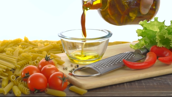 Bottle Pouring Virgin Olive Oil In a Bowl 