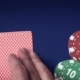 Royal Flush In Hand And Gambling Chips On Casino Blue Felt - VideoHive Item for Sale