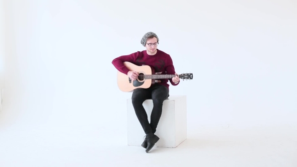 Man Playing An Acoustic Guitar On The White Studio Background