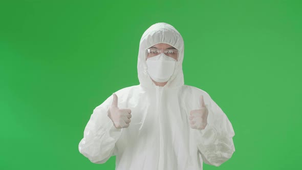 Asian Male Wear Protective Uniform PPE And Showing Thumbs Up In Green Screen Studio alt