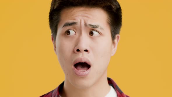 Portrait Of Shocked Asian Man Posing Standing On Yellow Background alt