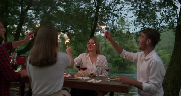 Youth Friendship Concept  Hands Toasting Red Wine Glass Beside River at Nightime alt