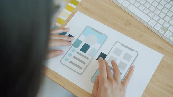 Closeup of Female Designer's Hands Using Color Palette and Paper with Smartphone Application Screen alt