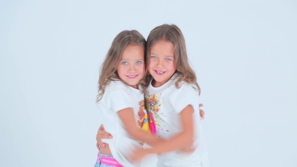 Little Girls Hugging And Laughing On The White Background