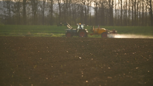Tractor Spray Fertilize On Field With Chemicals In Agriculture Field. alt