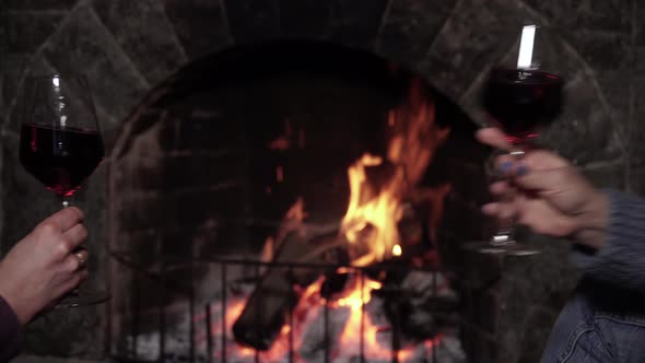 Two Women Clink Glasses with Each Other with a Glass of Wine alt