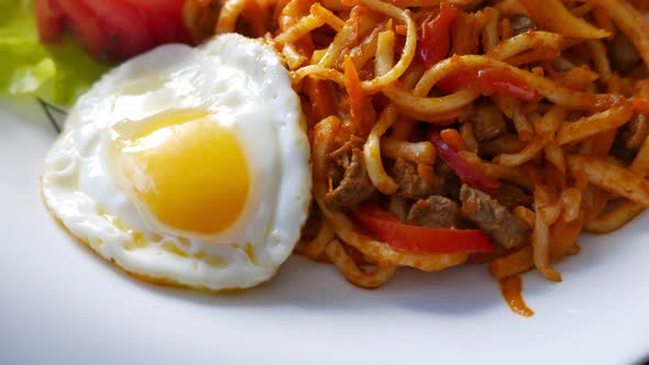 Roasted Noodles with the Scrambled Egg on a Plate  Asian Food Rotating alt