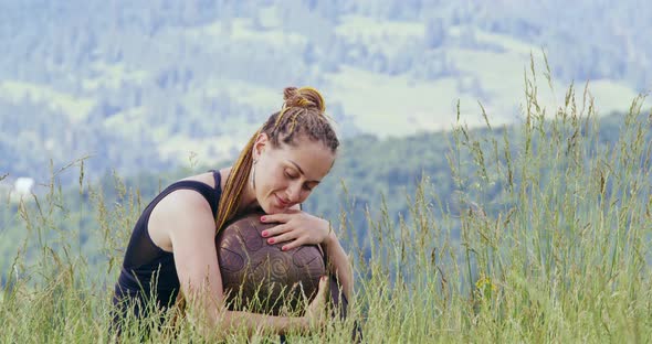 Woman with Hang Drum While Relaxing Among Mountains alt