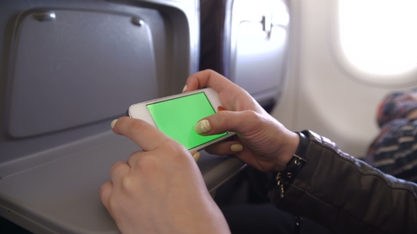 Woman Hand Using Cell Phone In Airplane