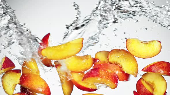 Super Slow Motion Shot of Flying Fresh Peach Slices and Water Side Splash at 1000Fps alt