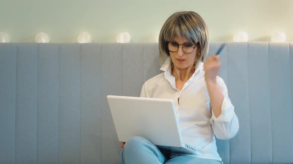 An Elderly Businesswoman Indignantly Communicates with Her Employees on the Phone and Solves