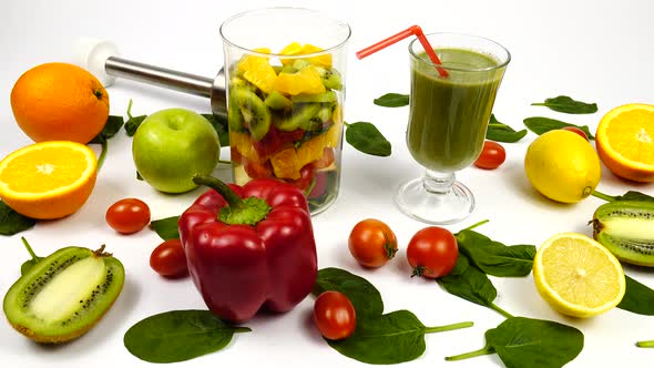 Kiwi fruit, fresh spinach leaves, lemon, orange, cherry tomatoes, apple and glass mug with a smoothi