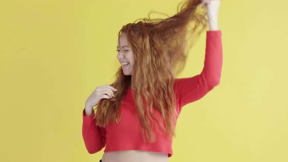 Funny cheerful female sexually shakes her hair and laughs in good mood