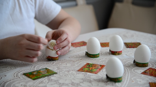 Boy Sticks Stickers On  Easter Eggs