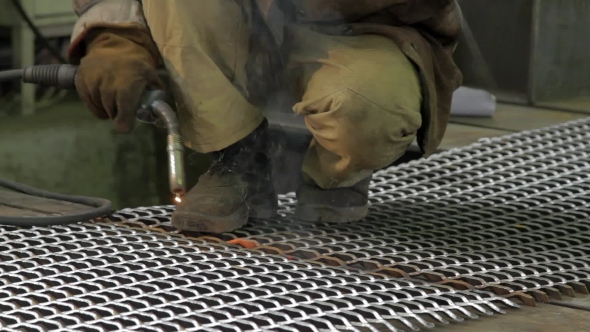 Worker Welds a Metal Sheets On a Factory 
