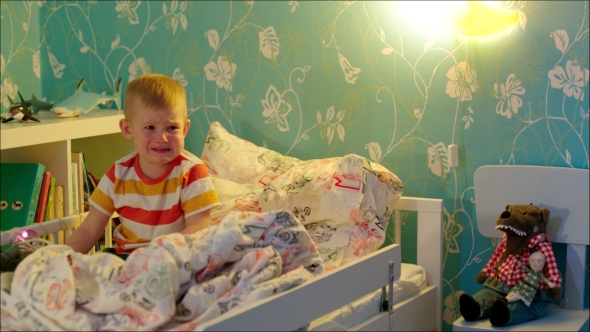 Little Boy Sitting And Crying In His Bed alt