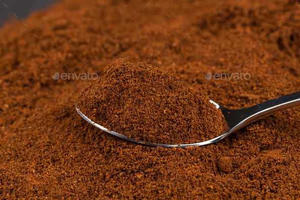 ground coffee and a metal spoon