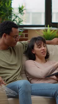 Vertical Video Diverse Couple Browsing Internet to Buy Decor on Laptop alt