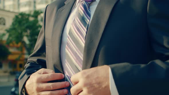 The Shot Moves Around a Businessman in Luxury Clothing Standing on a Street in the City Centeron a alt