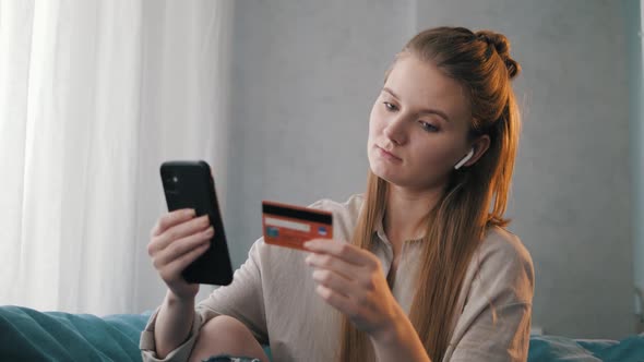 Pretty Young European Woman Customer Holding Credit Card and Smartphone.