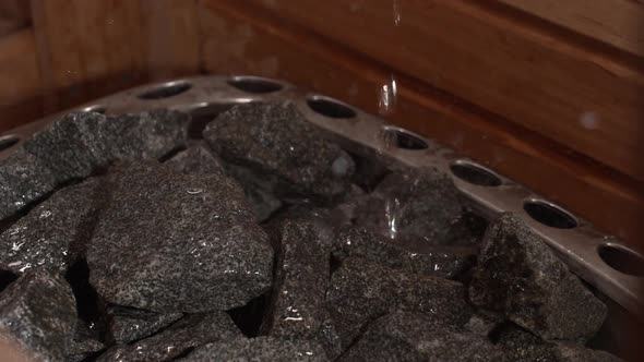 View of hot black stones in an empty sauna. Interior of wooden Finnish sauna for deep relaxation.Ove alt