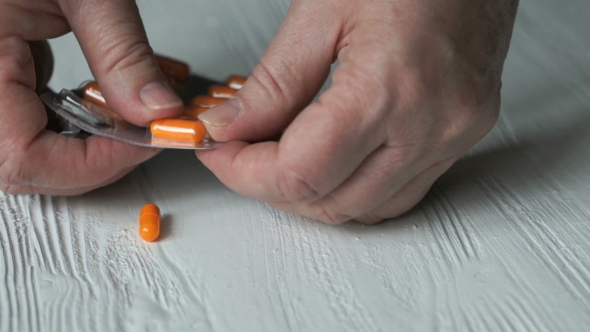 Hand Pulls Out The Tablets From a Blister Card