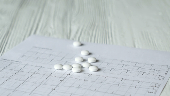 Woman's Hand Puts Off The White Tablets On a Table alt