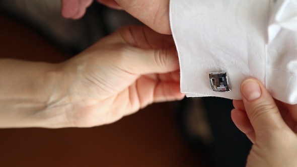 Woman Buttoning the Cufflinks for Men Shirt alt