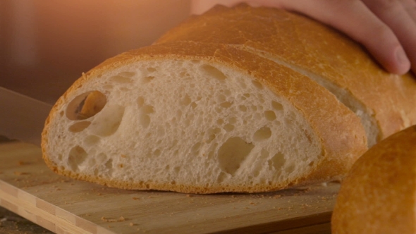 Hands Cutting Bread