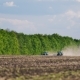 Tractor In a Field Is Planting. In The Background Forest And Blue Sky - VideoHive Item for Sale