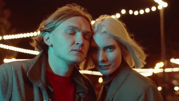 Young Couple Posing for Camera on Street in Night alt