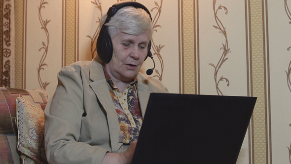Elderly Woman Communicating Using a Laptop at Home